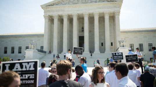 Washington DC, USA - June 27, 2016: Pro-life supporters hold signs in front of the U.S. Supreme Court after the court, in a 5-3 ruling, struck down a Texas abortion access law that had been supported by pro-life groups.